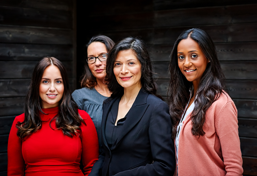 Four professional women standing side by side