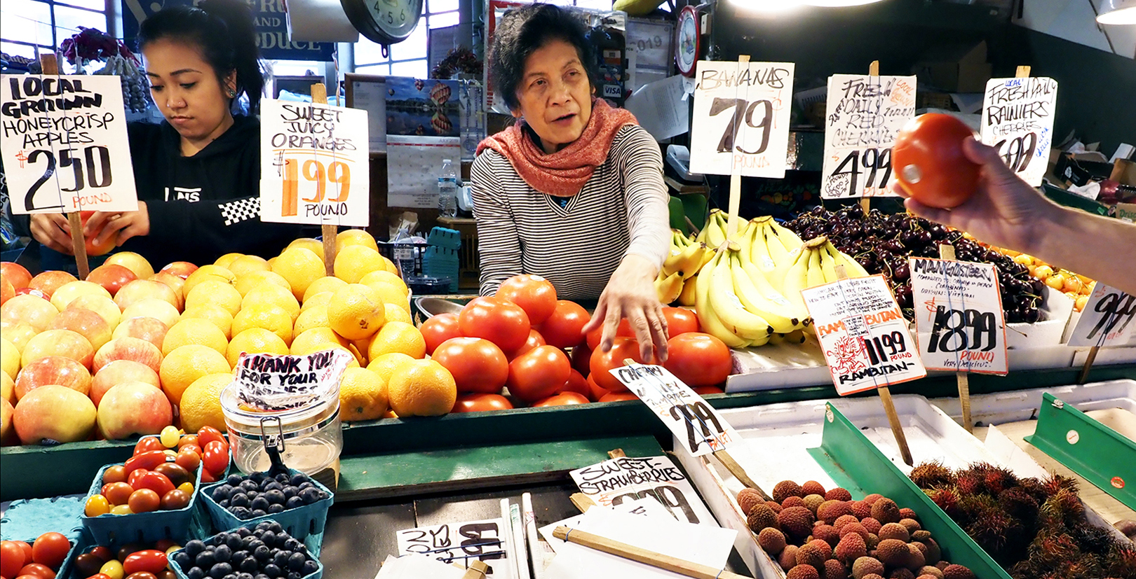Two women selling produce from a stall in Pike Place Market