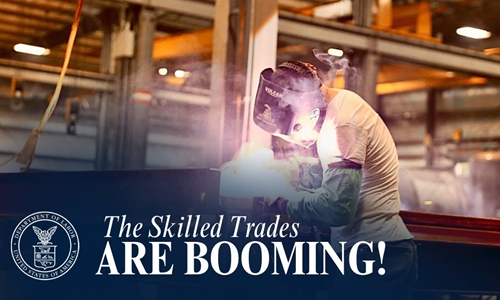 A worker wearing a face shield welds in a warehouse, with the text ‘The Skilled Trades are Booming.’