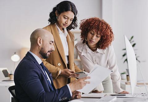 Small business team working on documents in front of computer