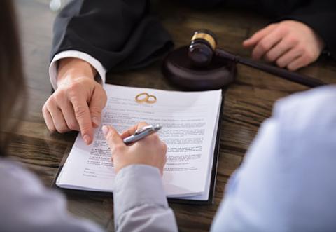 A woman signing divorce papers