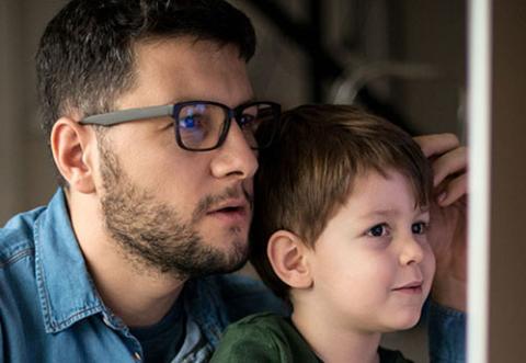 Father and son looking at a computer monitor