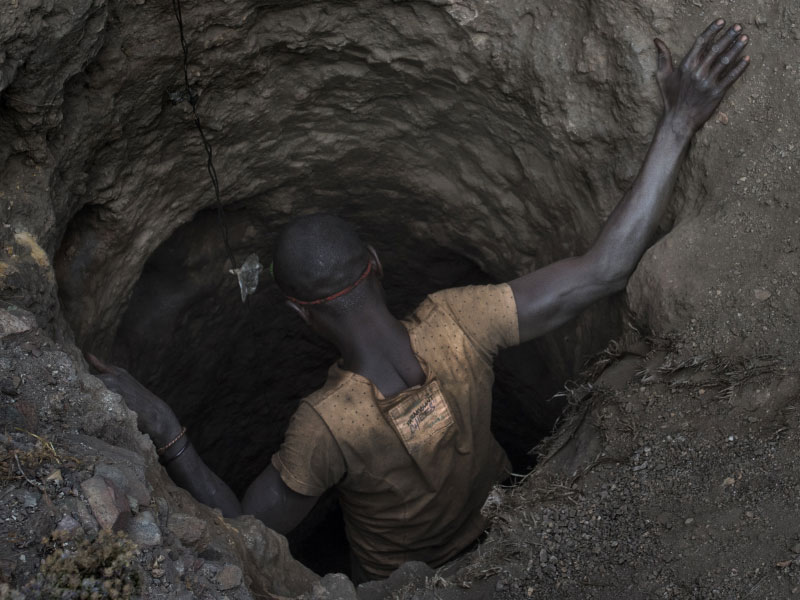 boy climbing down into a mine