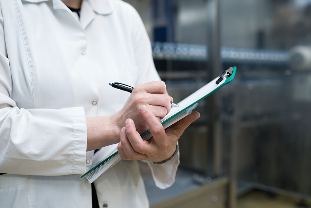 Image of medical professional writing on a clipboard