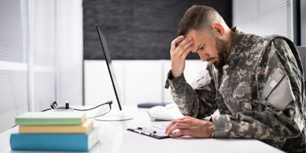 Man in uniform in thought seated in front of computer