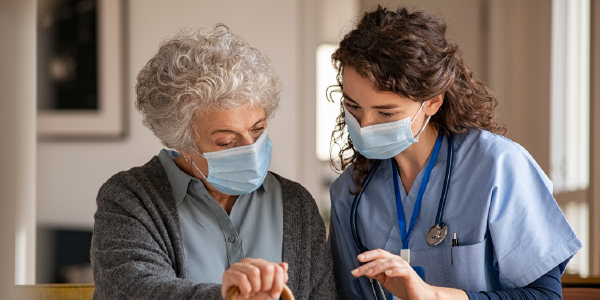 A home health care worker reviews a laptop with her client