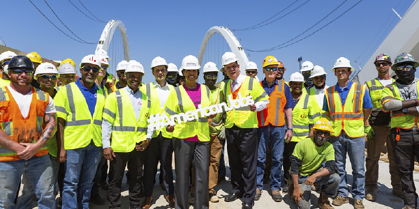 Secretary Walsh poses with workers at the Frederick Douglass Memorial Bridge.