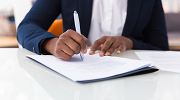 An African American businesswoman signs a contract.