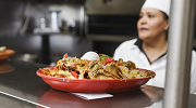 A plate of nachos prepared by a Latina cook is ready to be served.