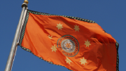 The flag of the Cherokee nation waves in a breeze.