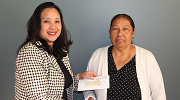 Garment worker Bertha Gonzalez (right) receives a check for back wages from Wage and Hour Division Los Angeles District Director Kimchi Bui. 