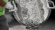 Close-up of a worker directing cement out of a cement chute.