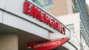 An emergency room sign marks a hospital entrance.