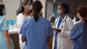 A group of healthcare workers in scrubs and face masks.