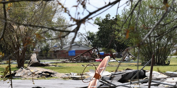 Structural debris, including a downed basketball hoop, are strewn across a yard in Mississippi following tornadoes. Photo by Anna Owens, DVIDS