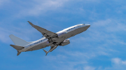 A passenger plane rises into a blue sky. 