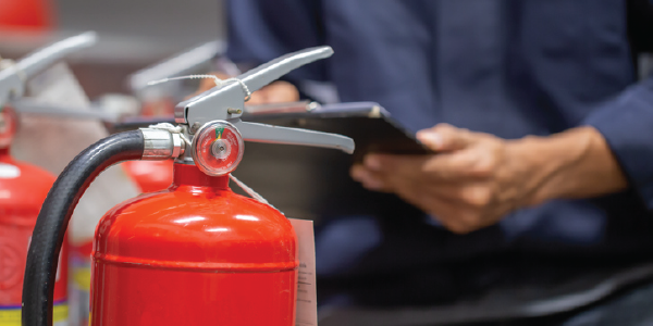 Engineer checking and inspecting a fire extinguishers tank in the fire control room for safety training and fire prevention.