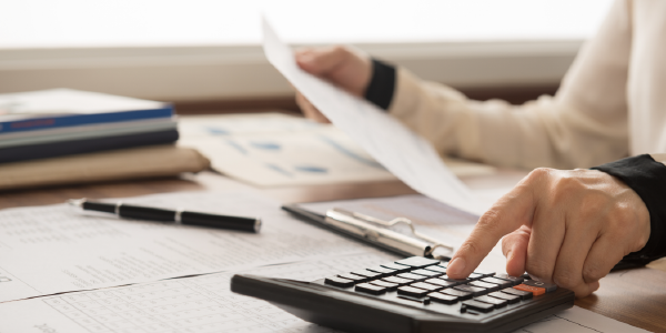 Man viewing paperwork and using a calculator