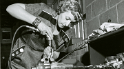 A black and white photo of a female engineer in the 1960s using power tools.