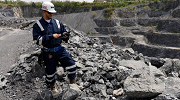 An MSHA inspector works on a tablet at an outdoor mine site