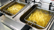 Close-up of fries sizzling in a deep fryer.