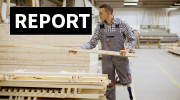 A man with a prosthetic leg stacks lumber in a warehouse. 