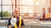 A construction worker removes his helmet on a hot day