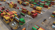 Shipping containers sit in a lot near a loading dock.