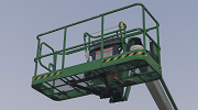 Low-angle view of a green aerial lift against the sky.