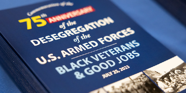 Photo of programs stacked on a table. They read: 75th anniversary of the desegregation of the U.S. Armed Forces. Black veterans & good jobs. July 25, 2023.