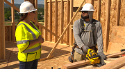 An OSHA safety and health compliance officer speaks with a construction worker at a job site. 