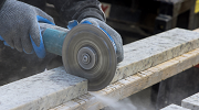 A rotating cutting tool slices through stone, generating silica dust.