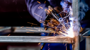 Close-up of a worker welding. The hot metal glows and sparks fly.