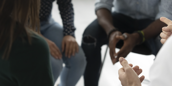 Close-up of a small group of people clustered together in a therapy session. 