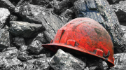 A red mining helmet laying on gray gravel.