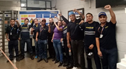 10 Mexican auto workers raise their fists in victory.