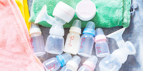 Breast pumps and bottles set out on terrycloth towels.