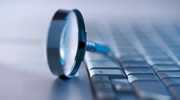 A magnifying glass on a computer keyboard.