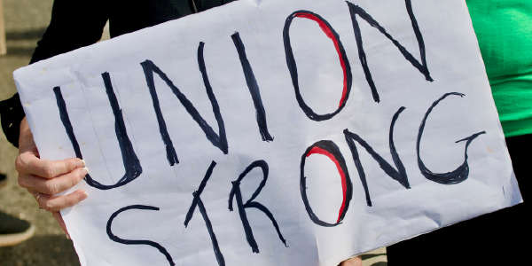 A Labor Day parade participant holds a poster reading âUnion Strong.â 