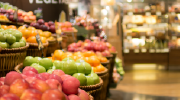 Apples and oranges are stacked in a grocery produce aisle.