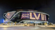 Exterior of a football stadium at night in Las Vegas. A sign reads Super Bowl LVIII