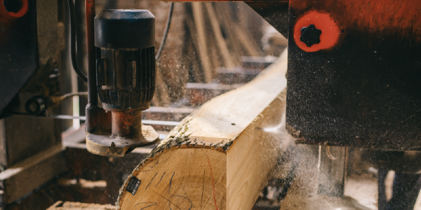 A machine slices through a log at a sawmill.