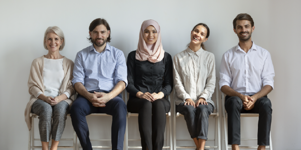 Five men and women of different ages and religious backgrounds sit in a row.