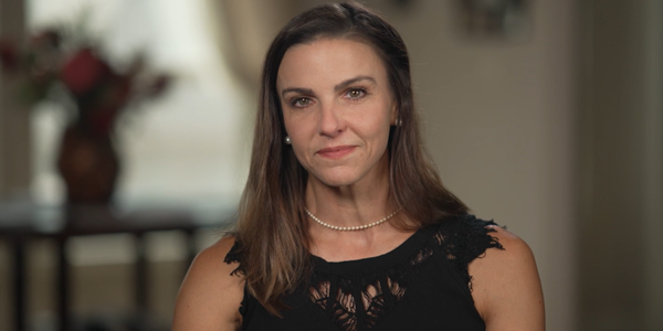 Headshot of Andrea Velasco, who has medium-length brown hair and is wearing a black shirt.