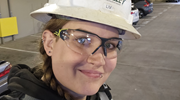 Close up of Olivia Yelton, an electrical worker, wearing a hard hat and safety goggles. 