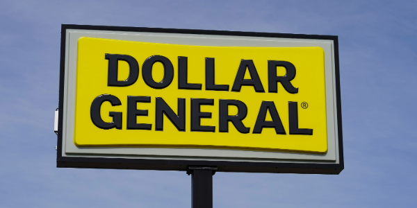 A large yellow and black Dollar General sign against a blue sky.