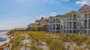 Beachfront apartments overlook grassy dunes along the Florida coast.