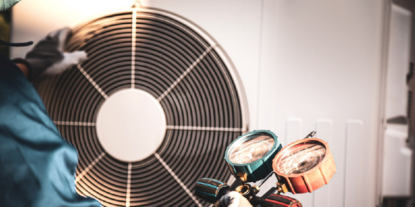 A technician is servicing a large air conditioning unit.