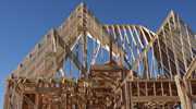 The wood framing for a large house under construction. The roof is steep.