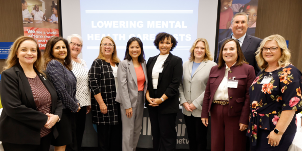 Acting Secretary Su and Neera Tandem pose for a photo with eight professionally dressed people in a conference room.